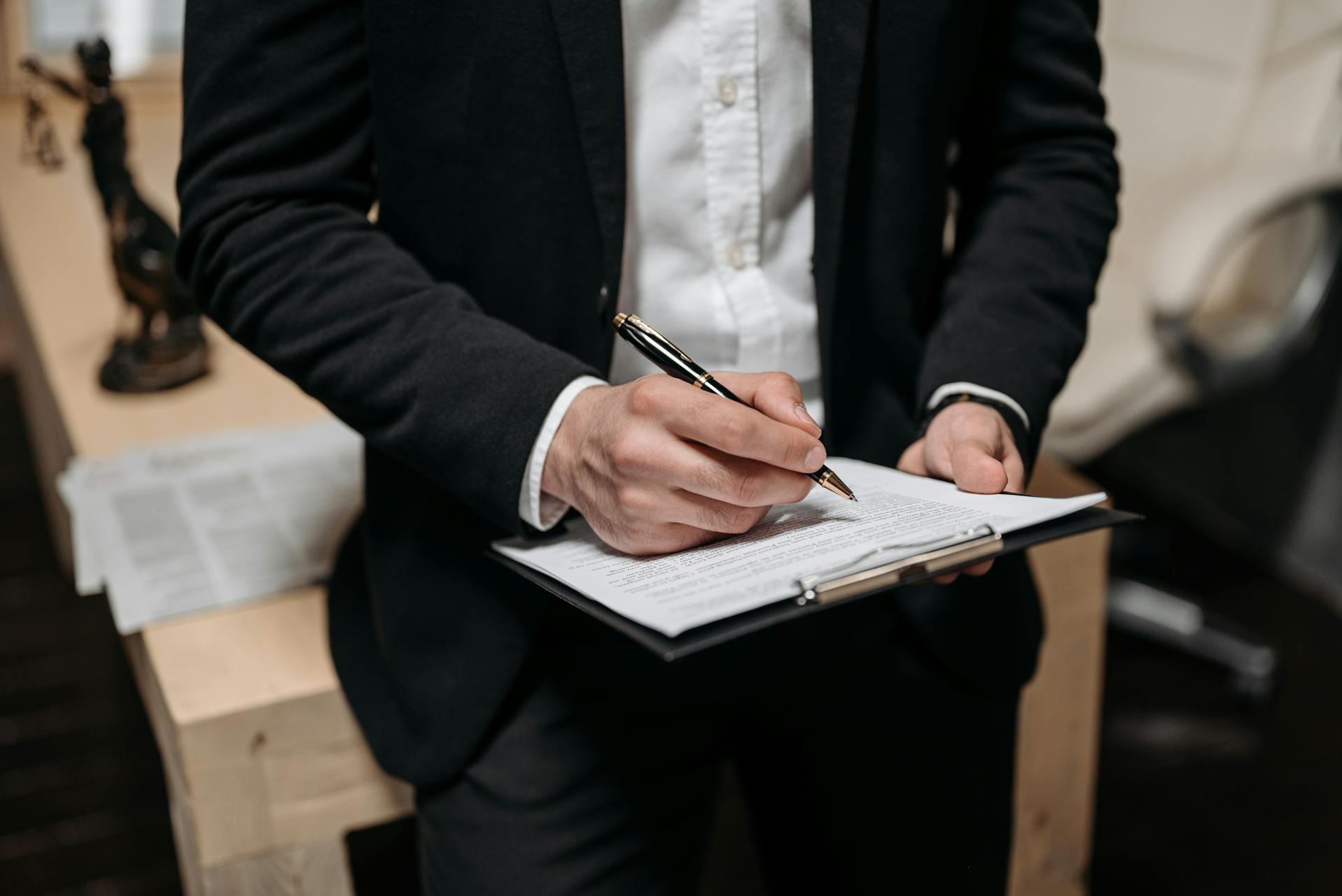 man signing legal document