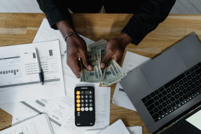 man counting money with calculator