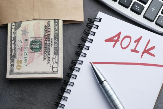 notebook with 401(k) and money